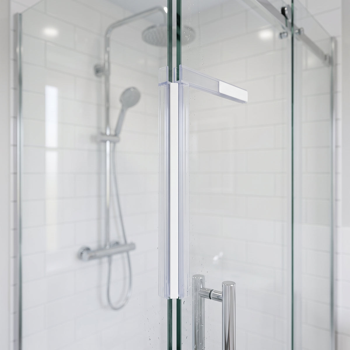 White magnet strip running full height where a sliding shower door meets the fixed glass panel