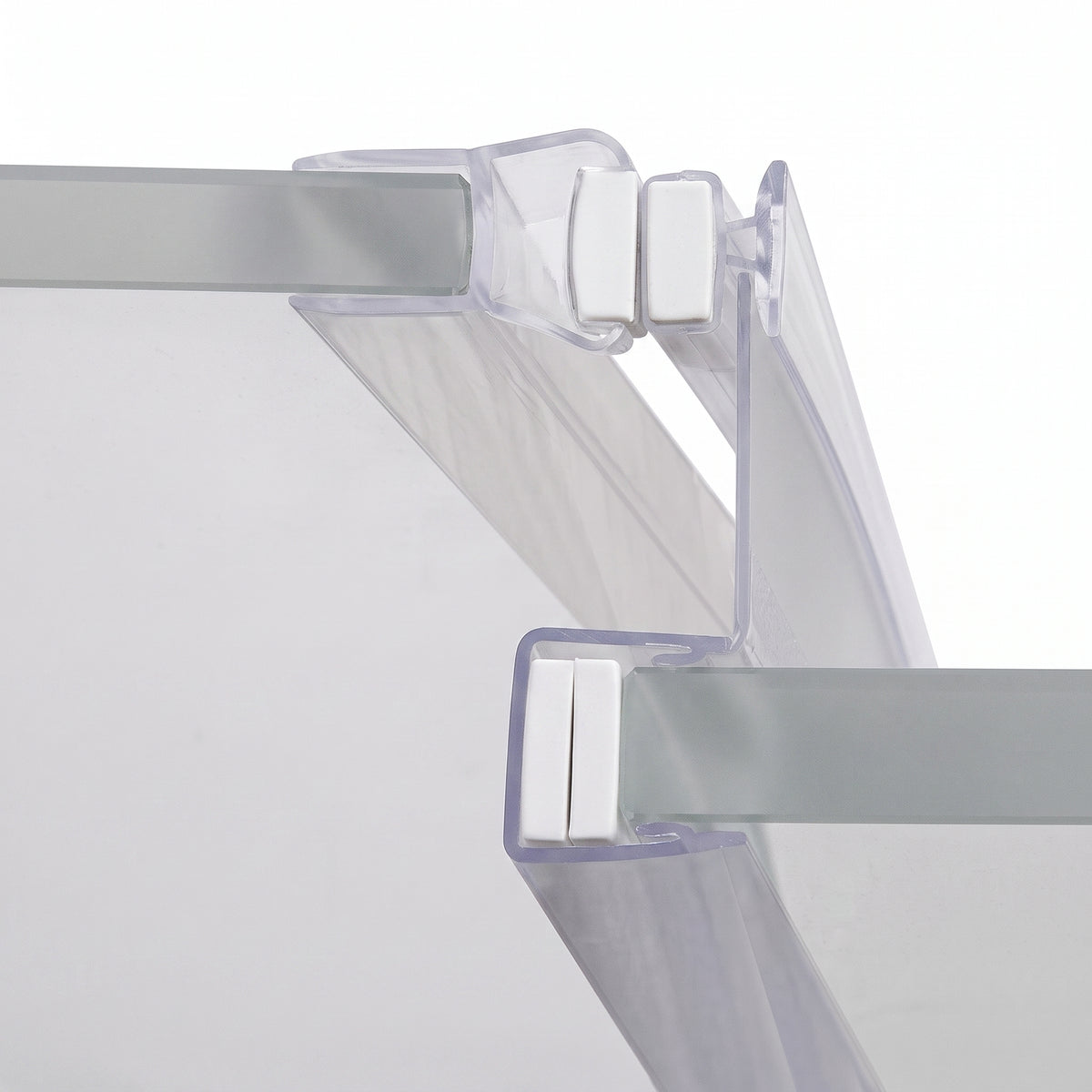 Clear seal profiles gripping two glass panel edges, white magnet blocks meeting where they close