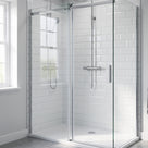 Corner shower enclosure with a sliding glass door and white metro tiles, seal not visible at this distance