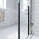 Clear magnetic seal on a hinged shower door edge with full-height black magnet strip closing at 90 degrees to the frame