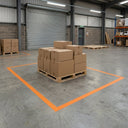 Orange floor marking tape outlining a goods-in bay with cartons stacked on a pallet inside it