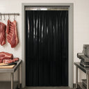 Black PVC strip curtain in a tiled butchery doorway, hanging meat cuts and a slicer either side