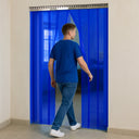 Man in a blue T-shirt walking through a blue transparent PVC strip curtain, seen from behind