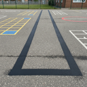 Black playground paint running track lane markings on a UK school playground