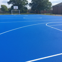 Blue playground paint MUGA court flooring with white game lines at a UK school