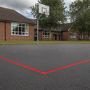 Post Office red playground paint boundary line on a UK MUGA court