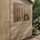 Clear panel fixed into the window opening of a timber garden shed, forks and hose inside