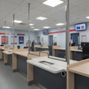 Clear screens above bank-style service counters in a bright retail branch interior