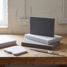 Grey and white polyethylene foam slabs stacked on a workshop bench with a shaped foam pad cut from one and a long knife