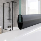 Black seal with a large hollow bulb on a glass bath screen edge, black-framed shower behind