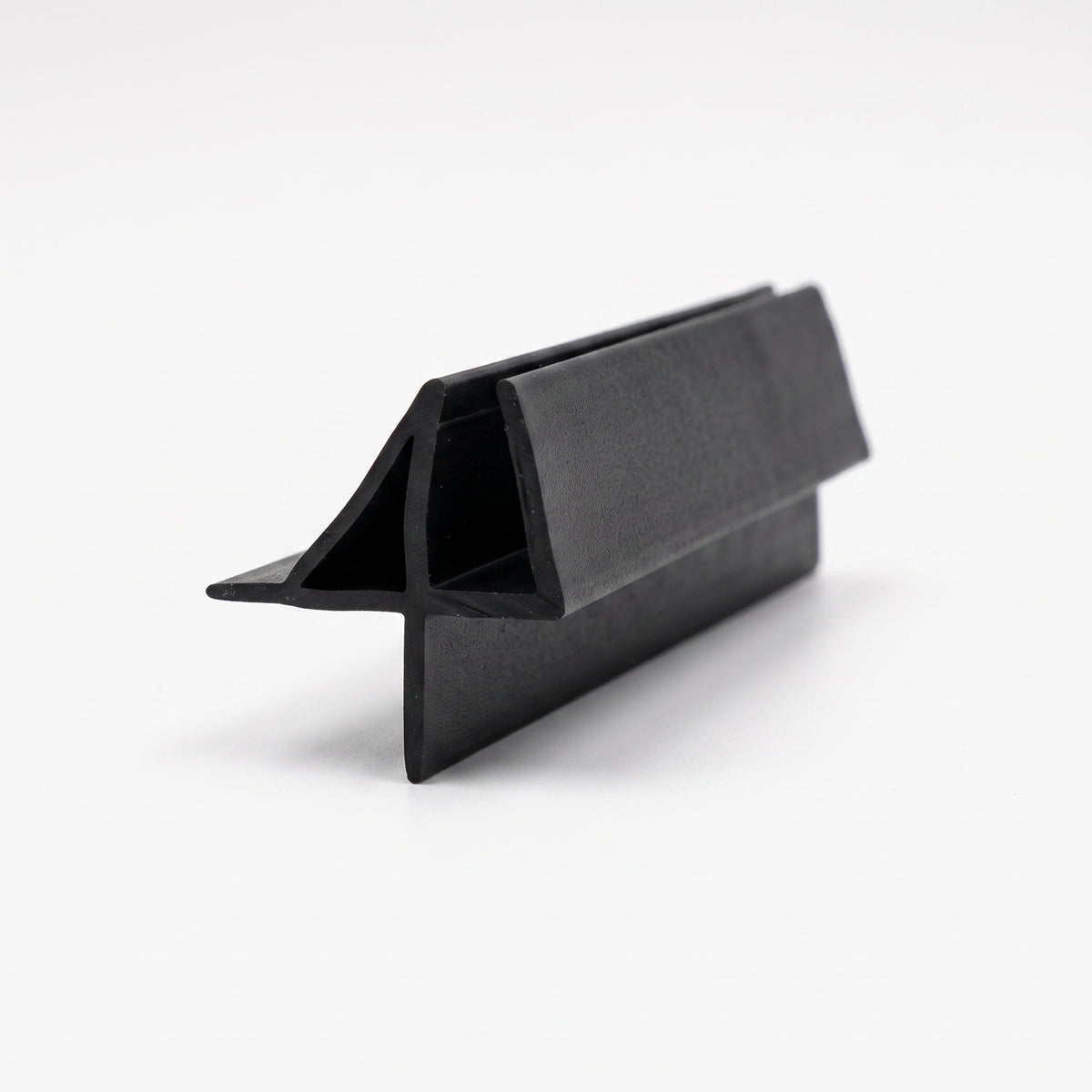 Black seal offcut on white, glass channel with an angled top fin and a straight lower blade