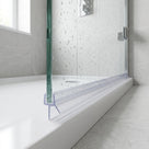Clear seal with a straight drop fin along the foot of a wet glass bath screen on a white bath