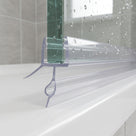 Clear seal on a bath screen bottom edge, bead-tipped blade and side fin spread across the bath rim