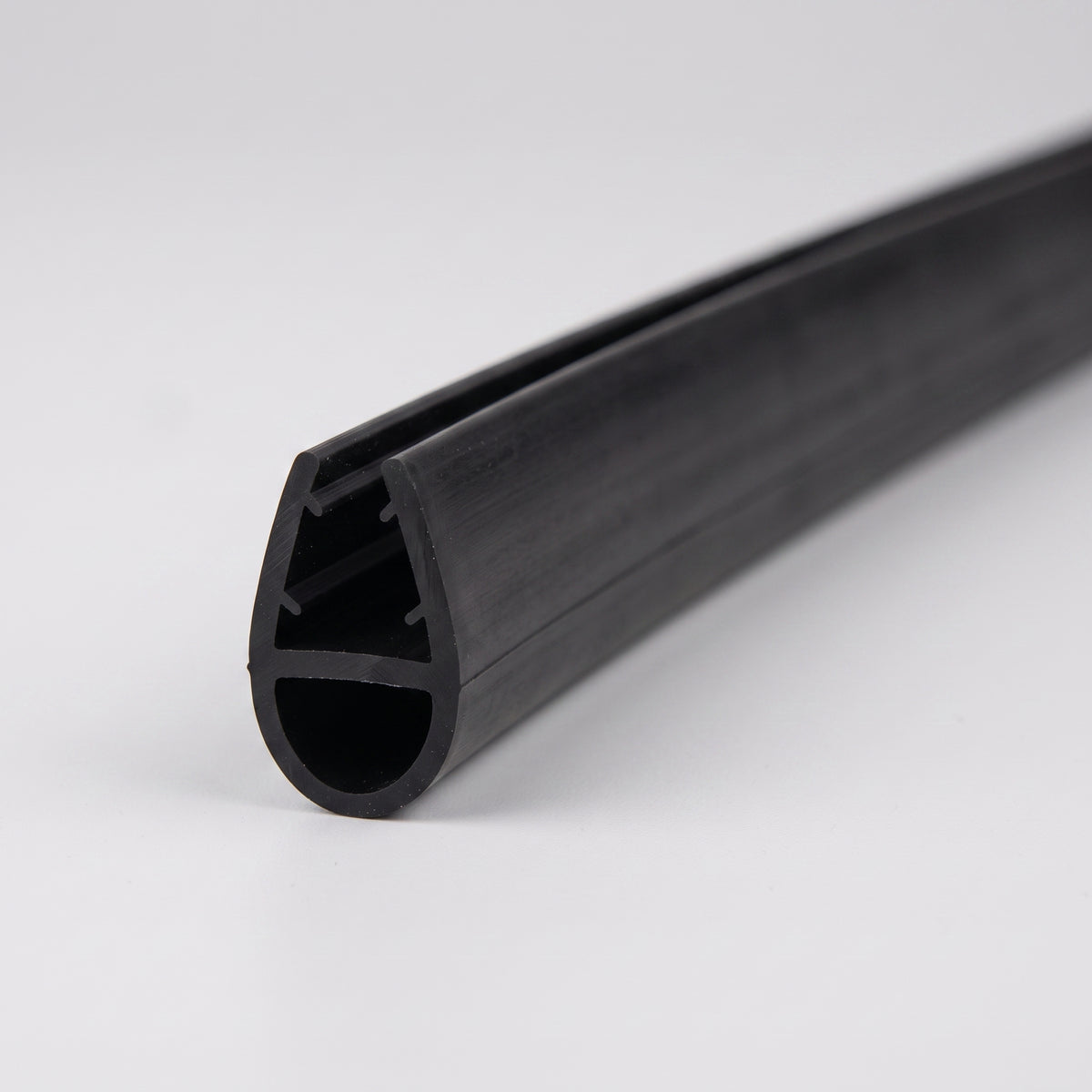 Length of black shower seal on white, glass channel above a large round hollow bubble
