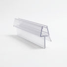 Clear shower seal offcut on white, glass channel with a long angled blade dropping from one side