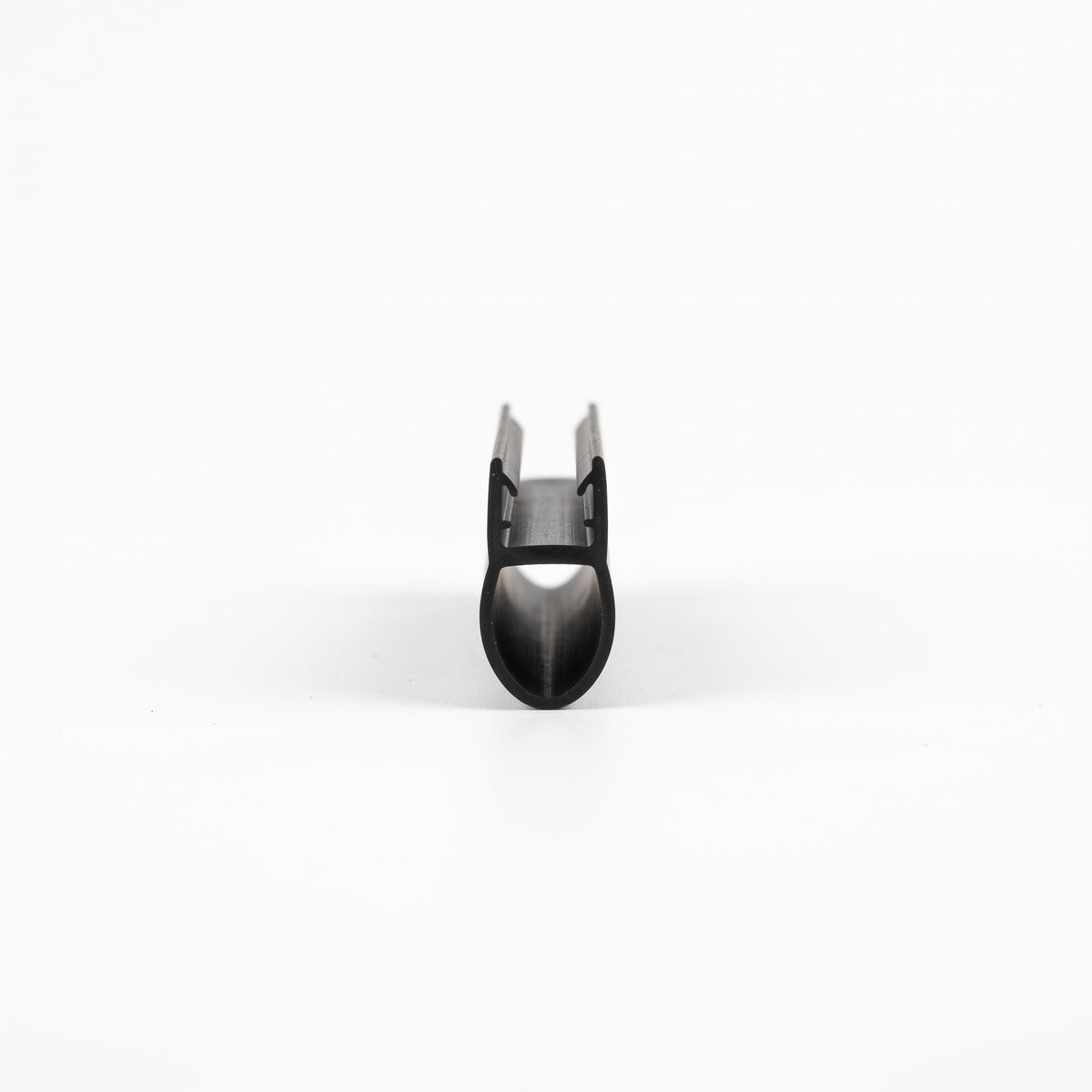 Black seal offcut viewed end-on, glass channel above a hollow teardrop bubble
