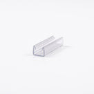 Short offcut of clear U-channel seal lying at an angle on a white background, open channel facing up
