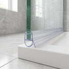 Clear bulb-loop seal under a glass screen edge on a white tray, marble-look tiles and window left