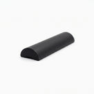 Cut length of solid black half-round threshold seal on a plain off-white studio background