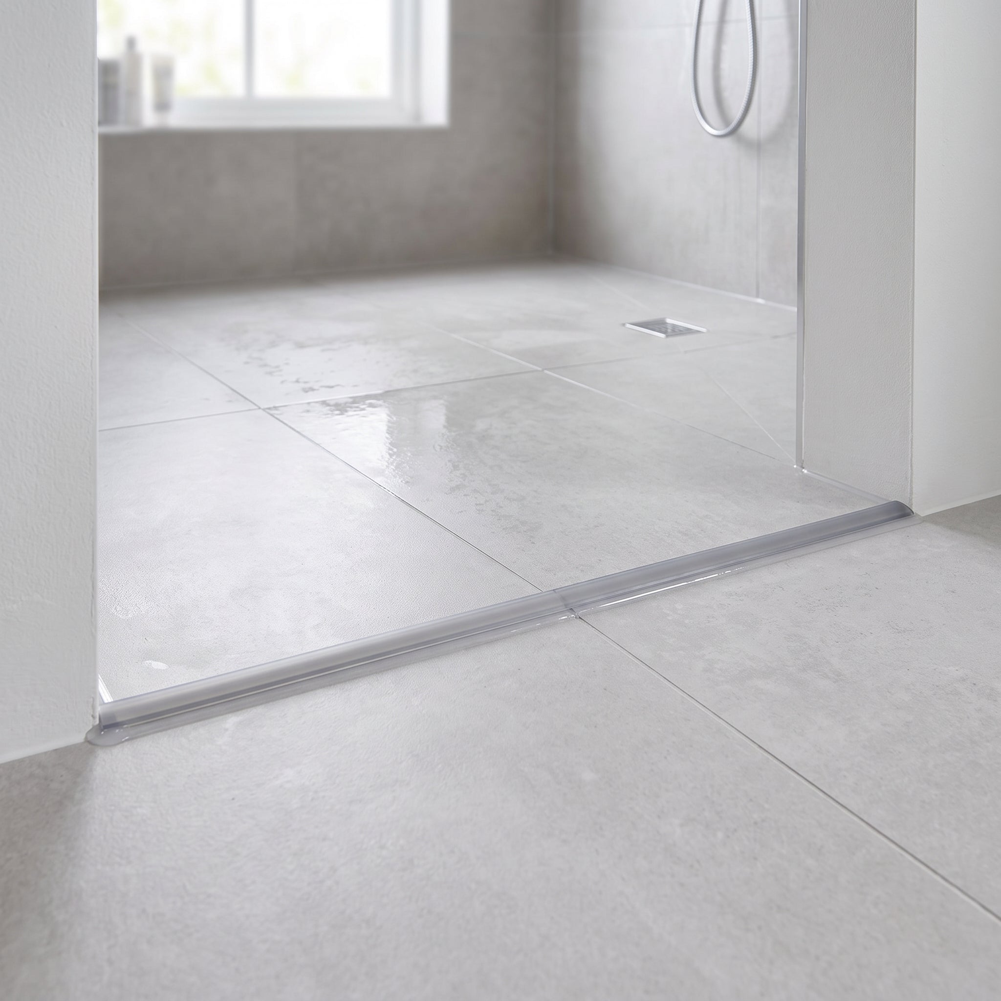 SEAL055G semi-transparent threshold seal siliconed across a wet room entrance keeping water inside