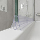 Clear seal on the bottom edge of a glass shower panel, angled fin and bulb stem on a white tray