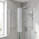 Clear corner seal running down the join of two glass shower panels, rain shower head and riser rail behind
