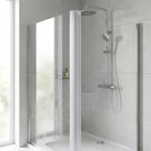 Clear vertical corner seal on the edge of a glass shower panel, chrome shower and tiled wall behind