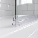Clear seal on a glass bath screen bottom edge, splayed legs standing on a white bath, metro tiles