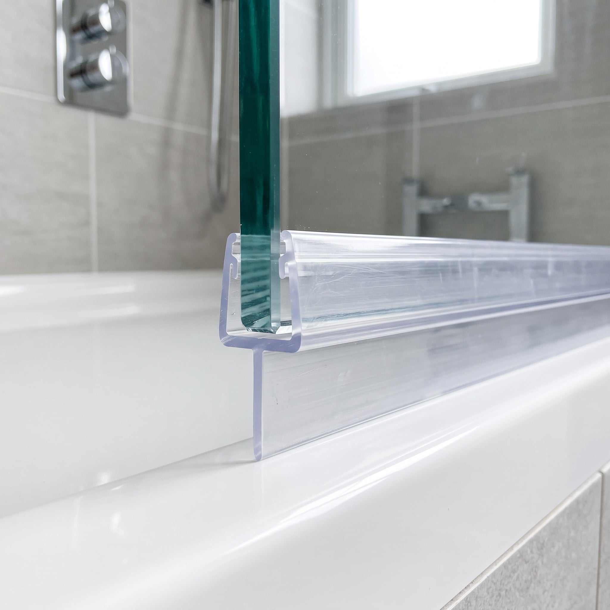 Clear seal on thick 10-12mm frameless glass with straight 10mm fin sealing the gap to the shower tray