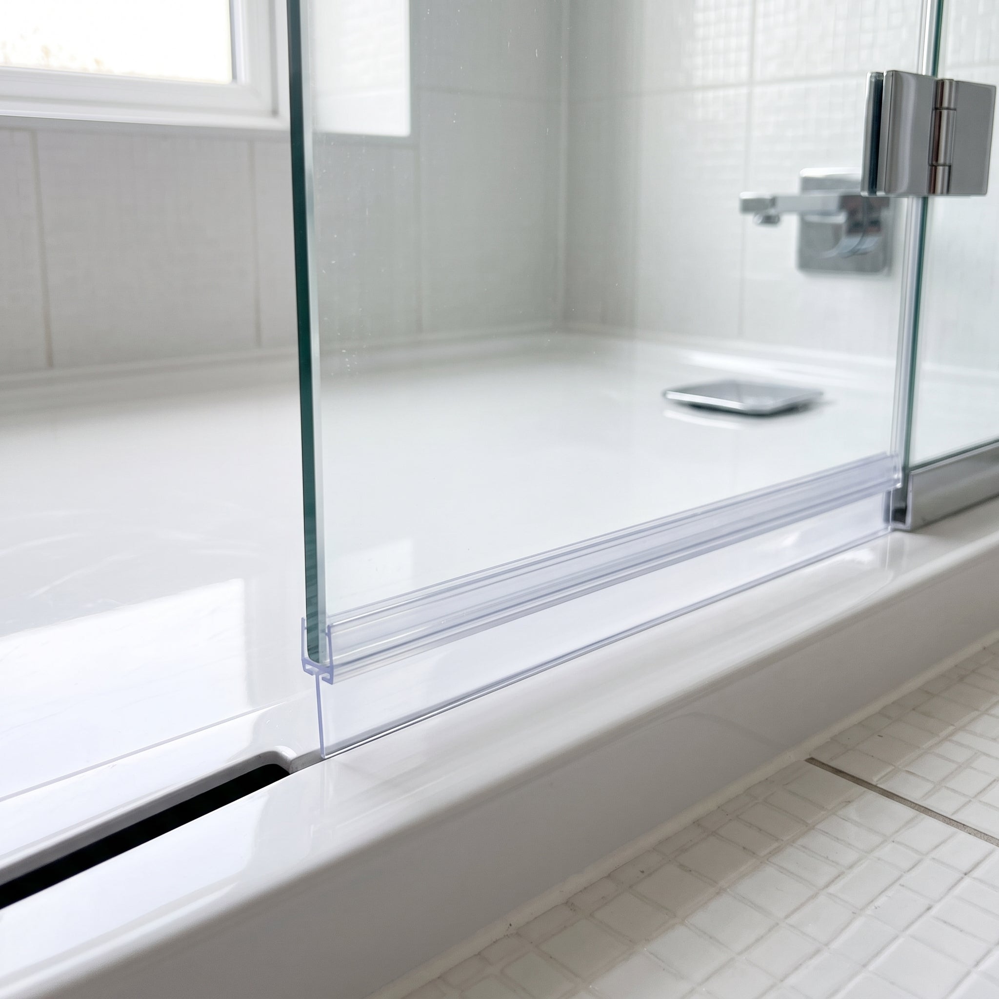 Clear SEAL083T seal on a 4-6mm glass door bottom edge - T-blade closing the gap to the tray