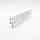 Cut length of clear shower seal on white, angled view - glass channel with a short straight T-blade underneath