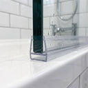 Clear SEAL085 carrier on a 10mm glass door bottom edge - zero-gap channel with empty T-slot track