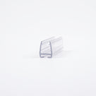 Clear T-seal carrier offcut on white, angled view - U-channel with ridged grip lips and an empty T-slot