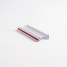 Clear I-join seal offcut on white, bow-tie section with a red 3M tape liner along one face