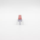 Clear two-part seal offcut upright on white, red VHB tape on the carrier top and a T blade slotted below