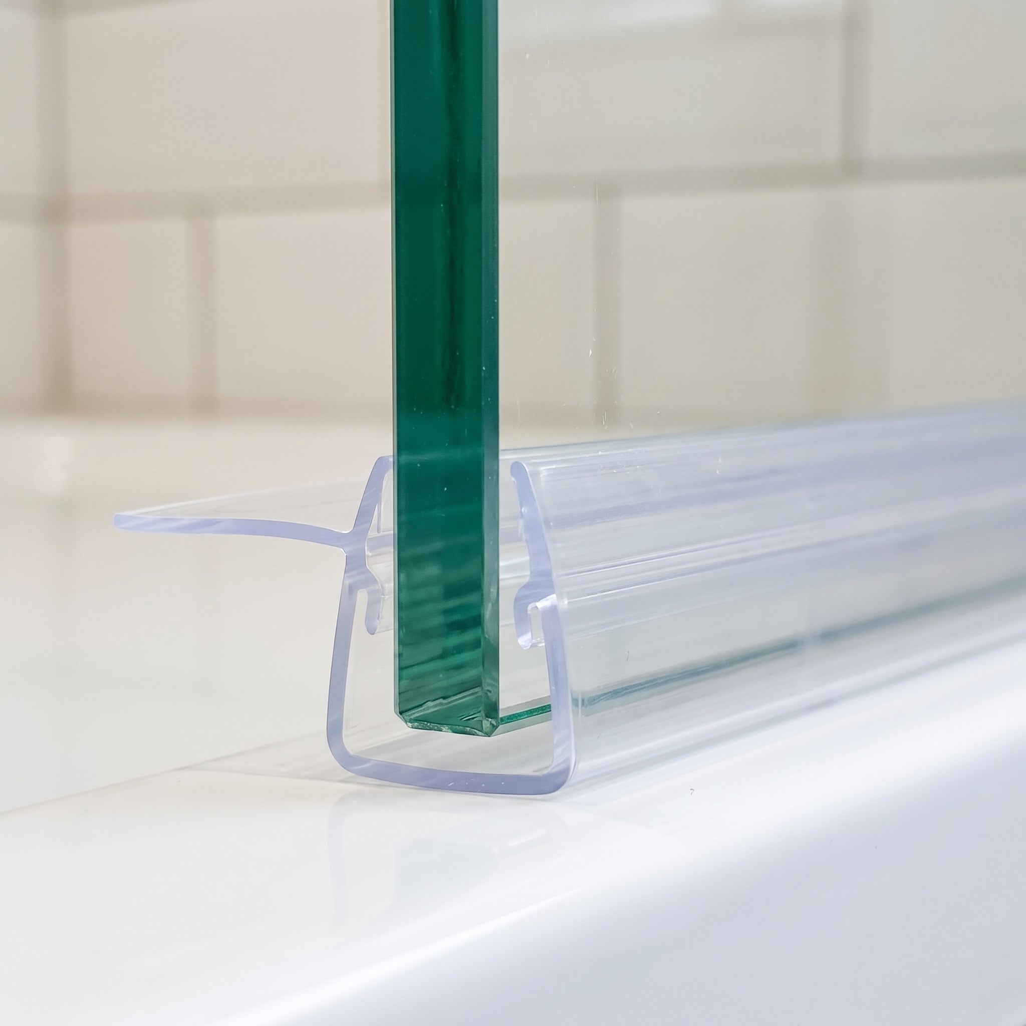 Clear fin seal capping the edge of 4-6mm glass, soft 20mm fin extending level with the channel mouth