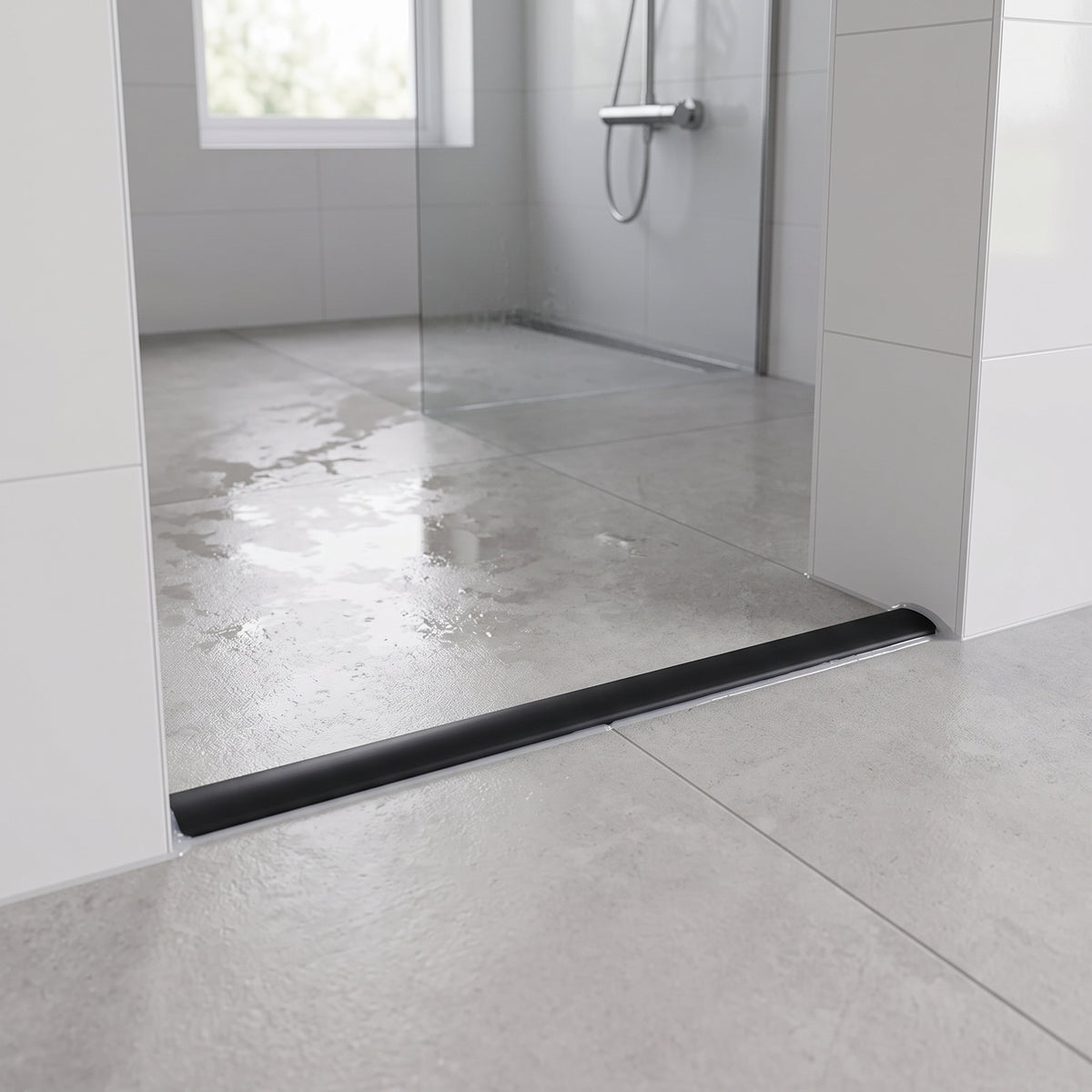 Black threshold strip laid across a wet room entrance, wet grey tiles and a glass panel behind it