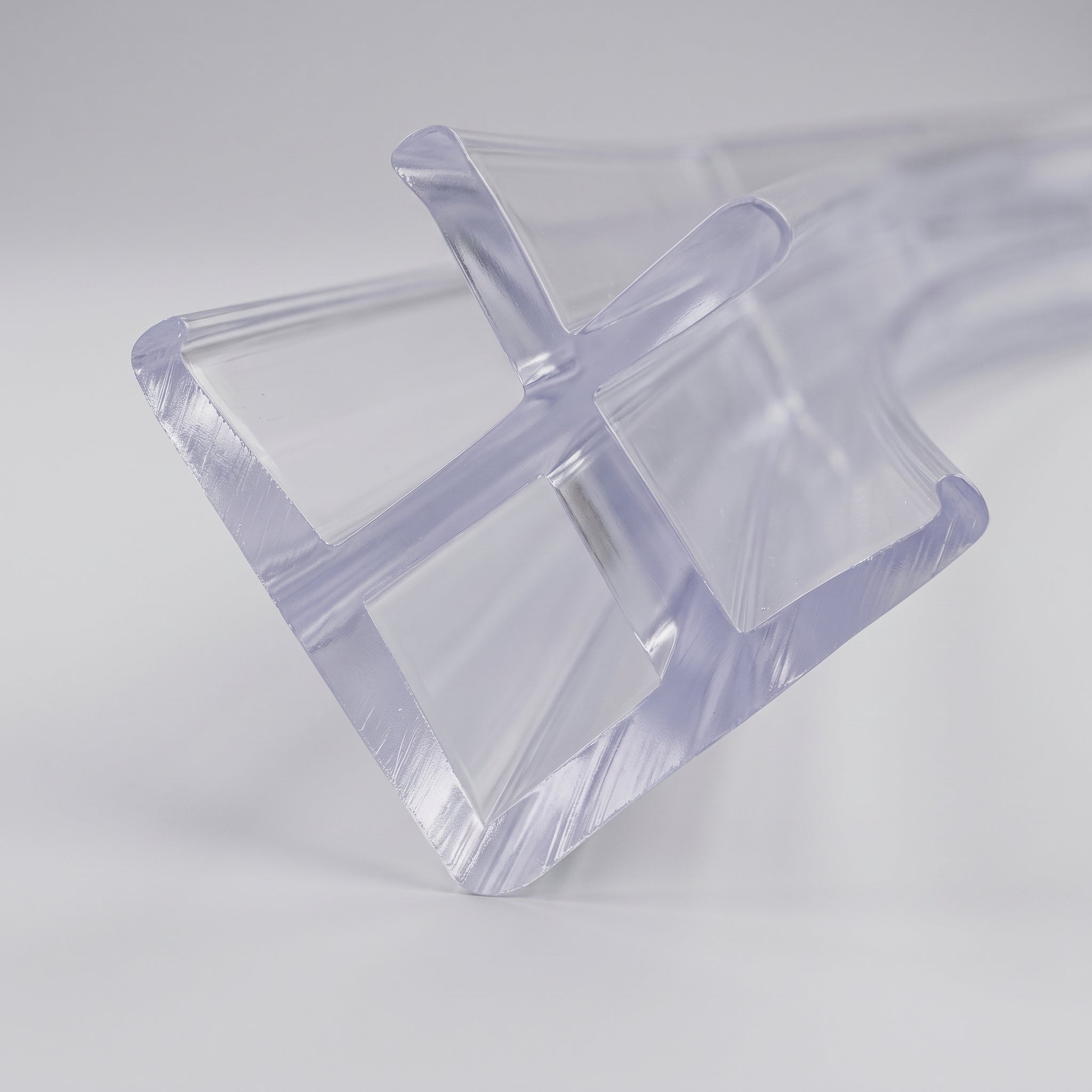 Studio shot of the clear PVC 90 degree corner seal profile - 14mm base with twin 5.5mm channels for two 4-5mm glass panels