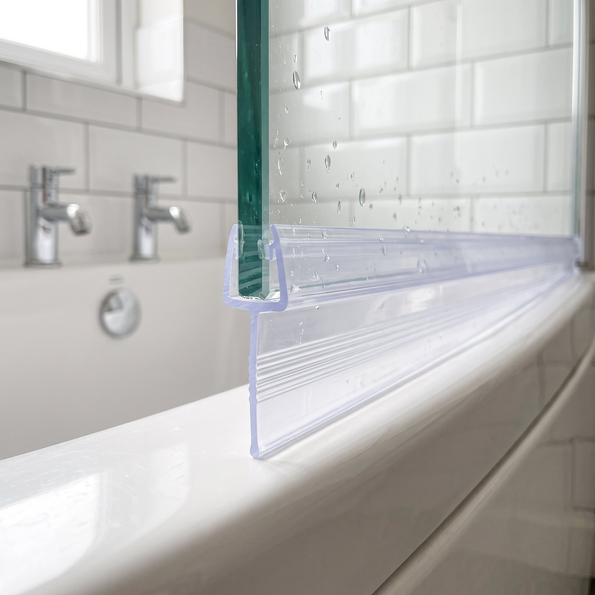 Clear tapered SEAL181 fitted horizontally on a bath screen - fin deepest over the widest gap, sealing to the bath rim