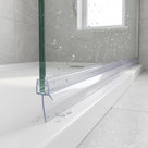 Clear seal on a green-edged bath screen, long fin fanned across the white bath rim, water droplets around