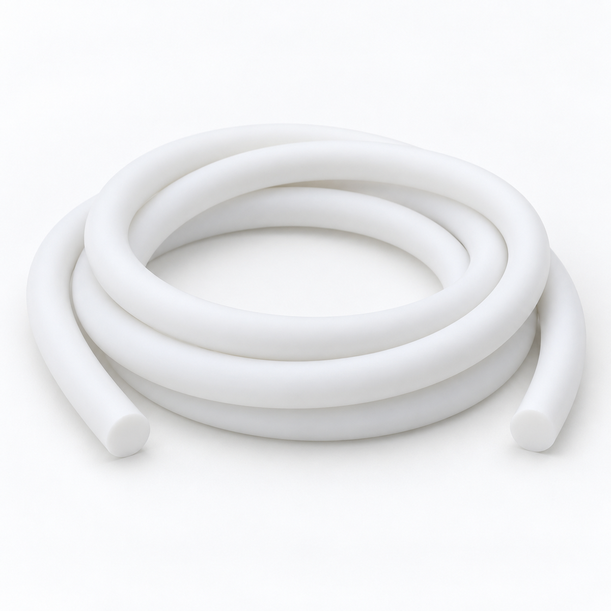 Matte white silicone cord lying in three loose coils on a pale grey ground, round cut ends facing forward