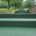 Dark Green FootGrip anti-slip step paint applied to concrete steps, public park steps beside a lawn and trees