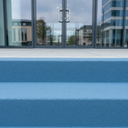 Mid Blue FootGrip anti-slip step paint applied to concrete steps, office building entrance steps with glass doors behind