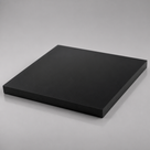 Square black slab resting on pale grey, matte face and a clean square edge along the front