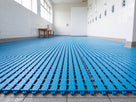 Ocean blue interlocking EVA barefoot tiles covering a communal shower and changing room floor