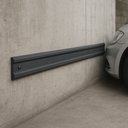 Dark grey rubber wall guard extrusion strip in car park - channeled rubber profile protecting wall from vehicle bumper and door contact