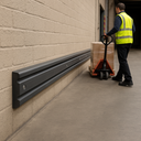 Dark grey rubber wall protector extrusion in UK loading bay - channeled rubber strip protecting loading dock wall from pump truck
