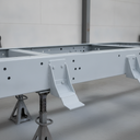 Vehicle chassis freshly painted light grey underbody protective coating in UK workshop