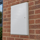 White recessed GRP electricity meter box installed in an exterior brick wall