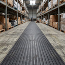 Black wide rib rubber matting laid as a walkway runner along a warehouse aisle between pallet racking